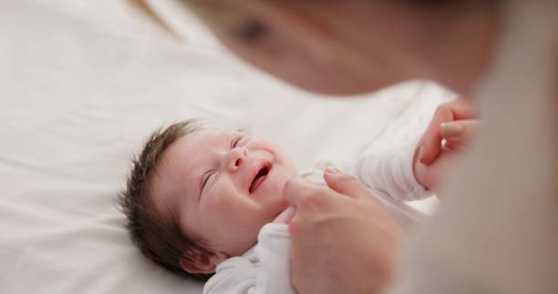 istock Baby, mother and playing on bed in nursery for bonding, love and support for child development. People, woman and newborn in bedroom of home with fun, hands or happiness for bond, care and smile 1993445604