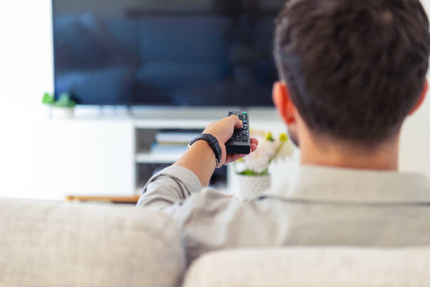 istock Man watching TV on the sofa during the day. 1993450804