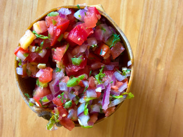 istock Mexican Cuisine: Pico di Gallo Salsa on Wood Table 1993465821