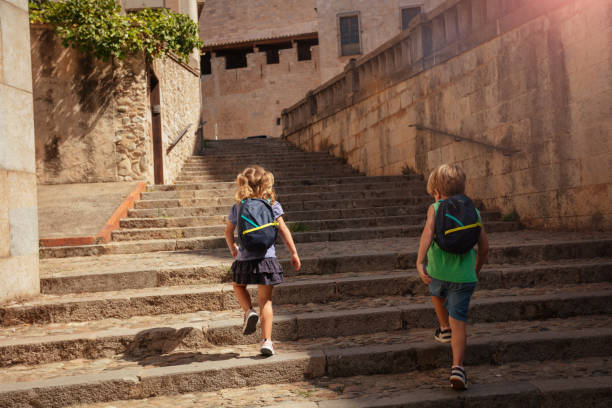 istock Two blond kids walk in Girona, go up stairs at historical part 1993477110