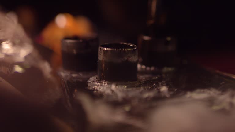 Extreme close-up of a tattoo machine. syringe going into a container to refill with ink