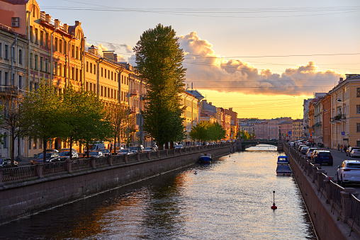 Cityscape of the Fontanka river, old residential buildings in the historical center of Saint Petersburg, Russia. Clear sky and evening yellow sunlight