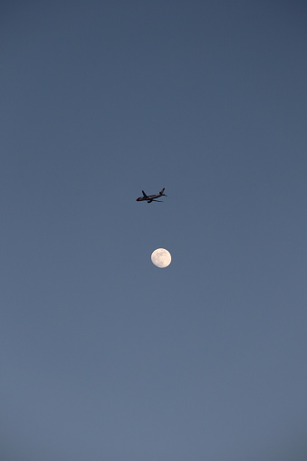 Plane flys over the moon