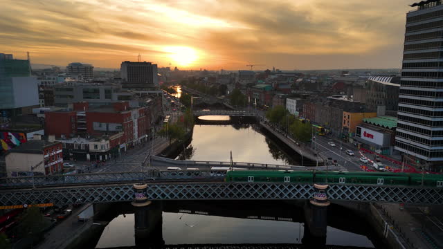 Aerial view of busy city center buildings and traffic at sunset, sunset aerial view of the river Liffey and city center in Dublin Ireland, aerial view of Dublin skyline and Samuel Beckett Bridge, sunset aerial view of Dublin city, Ireland