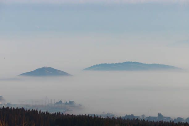 The lowlands in the mountains are covered with thick fog. In the background are mountain tops and blue skies. A beautiful landscape with fog