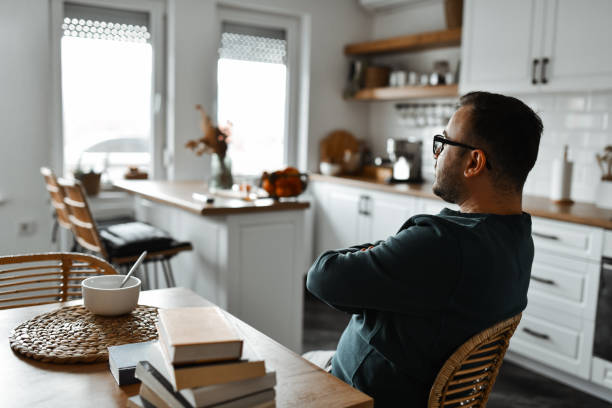 istock Male Contemplating Read Material While Eating Oatmeal 1993610394
