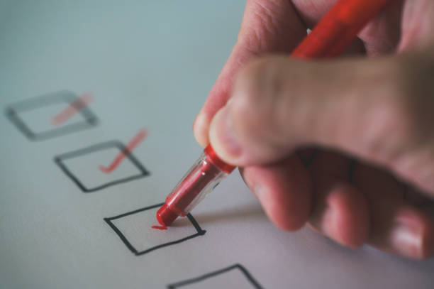 istock close up and selective focus hand using pen to making tick mark on check list box check list and marker 1993639978