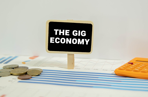 The Gig Economy text on notepad, concept background.