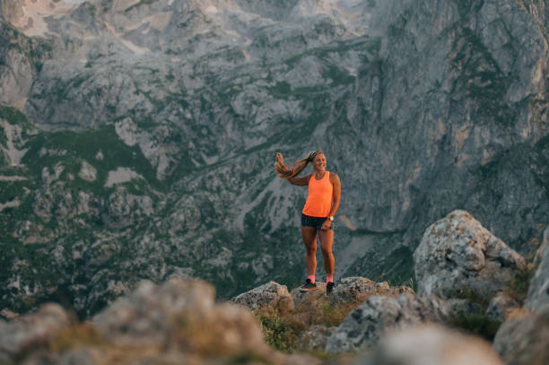istock An extreme skyruneer is standing on a cliff in mountains and resting. 1993697660