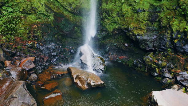 istock Waterfall stream crashing rocks aerial view. Force water falling mossy cliff 1993701766