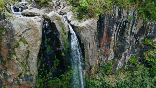 istock Water flowing high cliffs terrain aerial view. Force stream crashing mossy rocks 1993709015