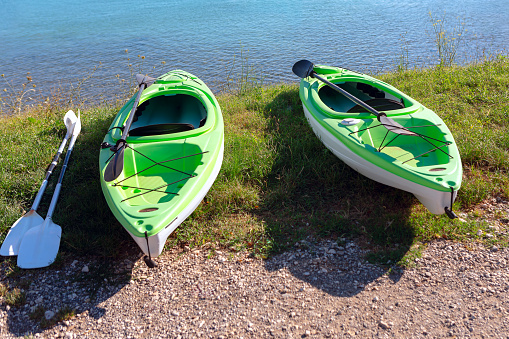 Two kayaks on the shore of a lake on a sunny day