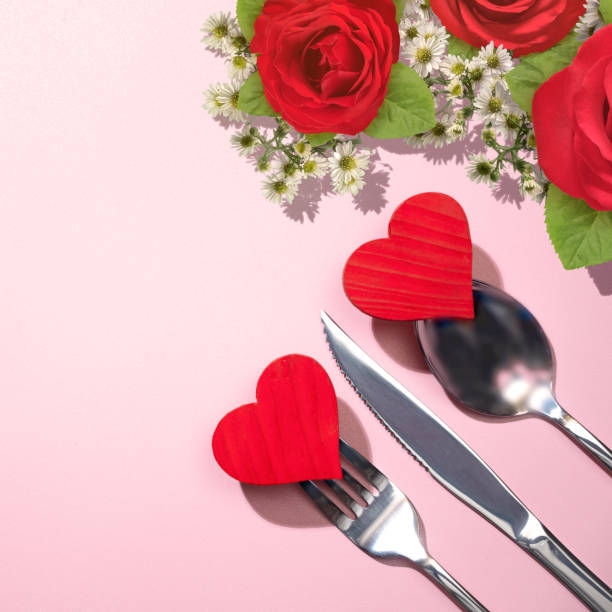 istock Silverware of fork, knife, and spoon with a red heart and rose flowerhead 1993761167
