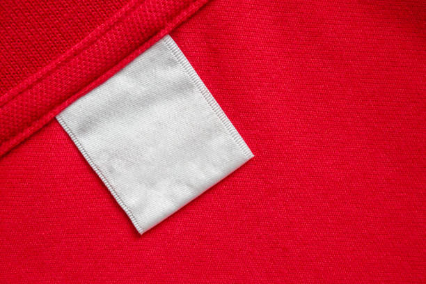 istock Blank white laundry care clothes label on red shirt fabric texture background 1993774267