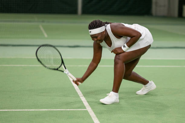 istock Tennis player bending down in court 1993776402