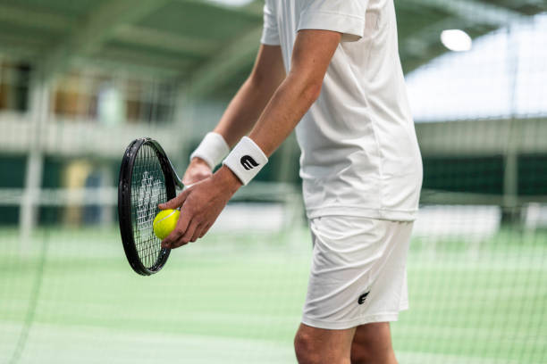 istock Tennis player with racket serving ball 1993776423
