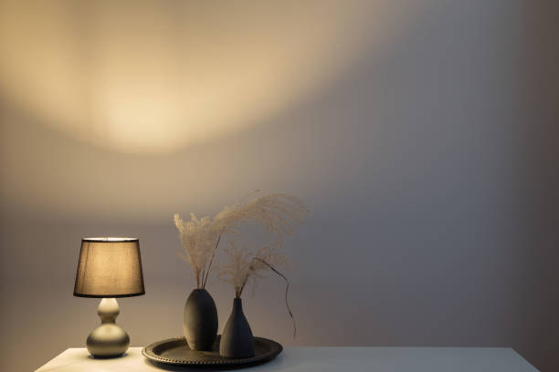 istock lamp with dried flowers in black vases on white shelf 1993782594