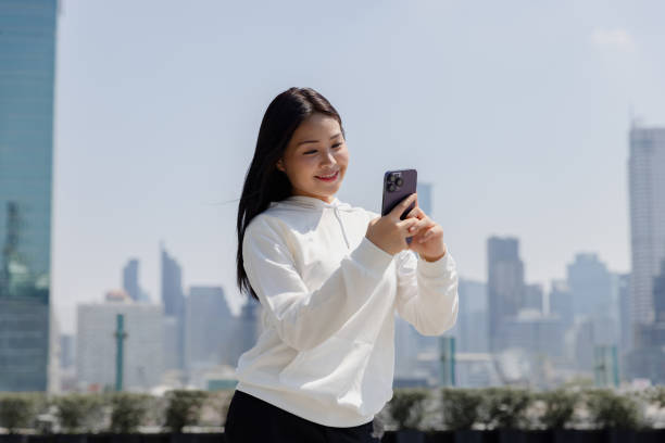 istock Young woman using digital device outdoor. asian. 1993884239