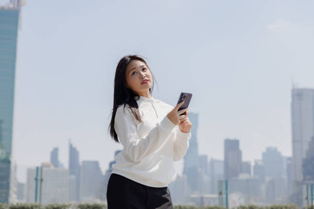 istock Young woman using digital device outdoor. asian. 1993884243