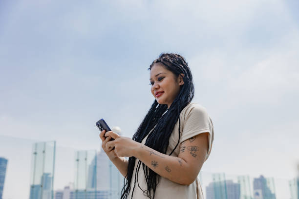 istock Young woman using digital device outdoor. asian. 1993884772