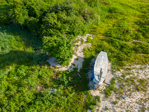 Aerial drone view of a boat marooned on the dried riverbank in Amazon region, a testament to the impact of the receding water levels