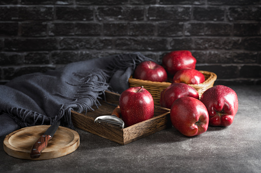 green and red apples on wooden table with small casserole