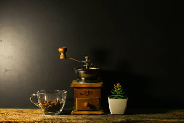 Coffee grinder and coffee beans put on old wooden with white background.