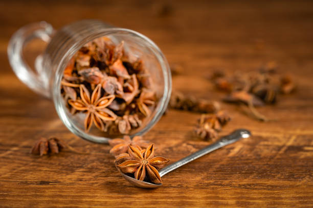 anise stars in a white bowl on wooden table