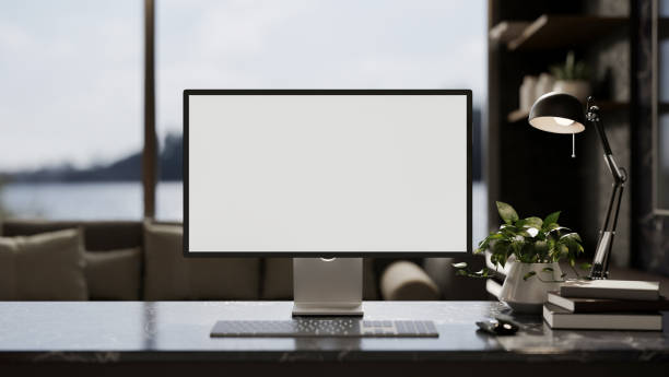 istock Modern home office workspace with a white-screen computer and decor on a modern black marble table. 1993983527