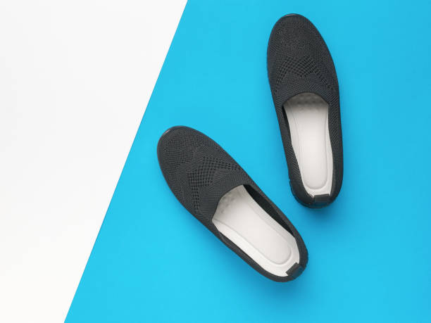 istock Dark cloth women's shoes on a blue and white background. 1993983787