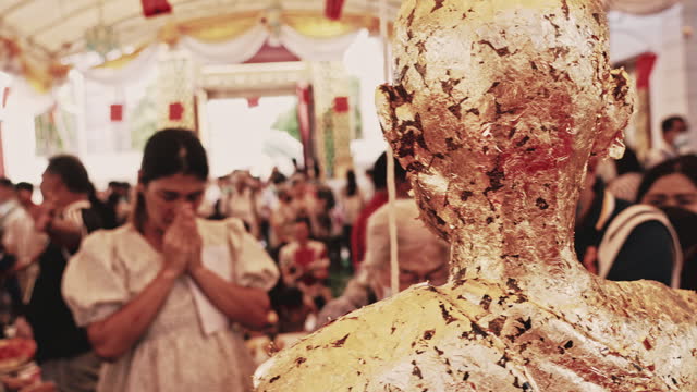 People praying at shrine of Buddha at Bangkok temple