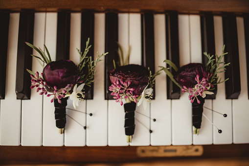 Purple flowers for wedding groomsmen on piano keys
