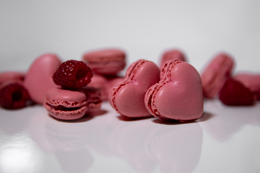Pink macaroons in the form of hearts on a white background