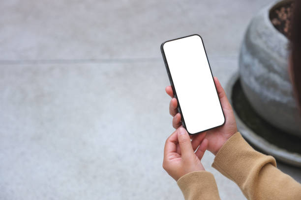 istock Mockup image of a woman holding mobile phone with blank desktop white screen 1994118540