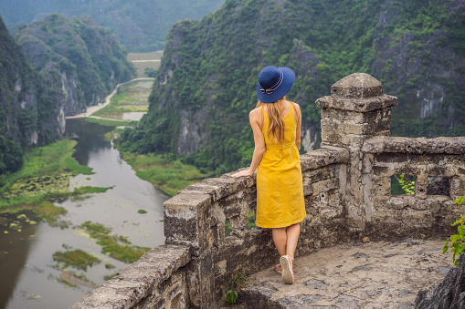 Woman tourist on the lake Tam Coc, Ninh Binh, Viet nam. It's is UNESCO World Heritage Site, renowned for its boat cave tours. It's Halong Bay on land of Vietnam. Vietnam reopens borders after quarantine Coronovirus COVID 19