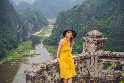 Woman tourist on the lake Tam Coc, Ninh Binh, Viet nam. It's is UNESCO World Heritage Site, renowned for its boat cave tours. It's Halong Bay on land of Vietnam. Vietnam reopens borders after quarantine Coronovirus COVID 19