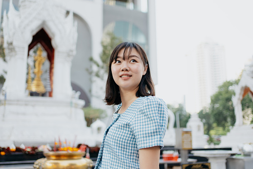 An Asian Chinese woman visit and exploring Trimurti Shrine in Bangkok, Thailand