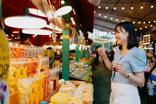 An Asian Chinese woman buying street food Mango Sticky Rice 