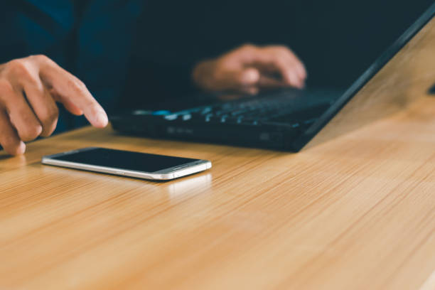 istock Men's hands use laptops and mobile phones, work at their desks, take close shots and work through technology. 1994258814