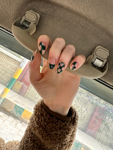 Stock photo showing close-up view of a woman displaying her manicured painted nails design.