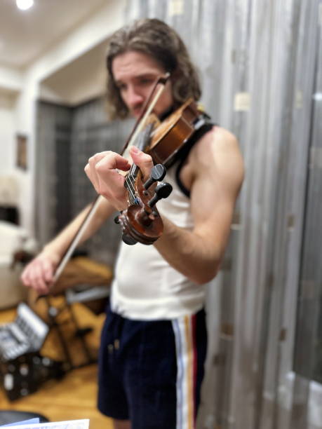 istock Young man playing violin at home 1994314468