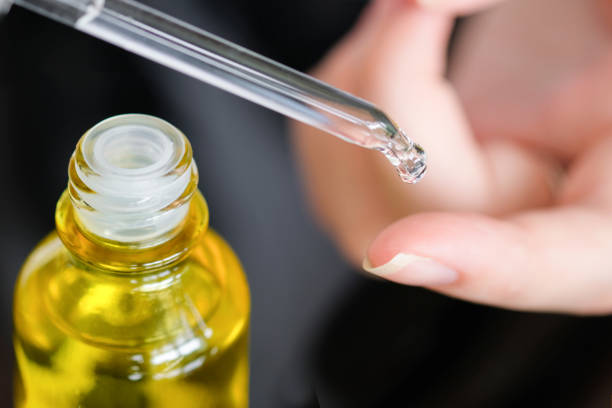 istock Dropping serum collagen moisturizer of face into clear yellow bottle soft light background. Protector skin Treatment facial essence oil, Vitamin C. Beauty and spa Concept. 1994316853