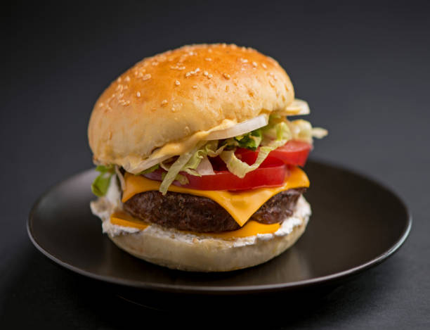 istock Big tasty burger with beef cutlet on a black background 1994332909