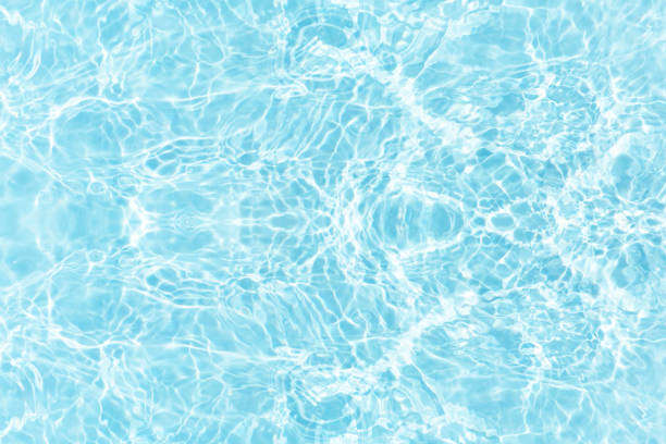 istock Water surface. Bluewater waves on the surface ripples blurred. Defocus blurred transparent blue colored clear calm water surface texture with splash and bubbles. Water waves with shining pattern. 1994388631