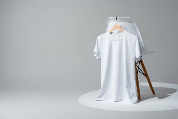 istock White blank t-shirt hanging on chair in empty room 1994389168