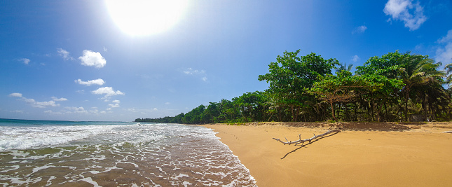 A captivating deserted beachscape with a radiant sun in a clear sky in Ghana, Africa