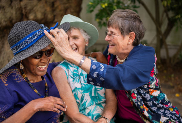 istock Senior women laughing while sitting together on a park bench 1994419269