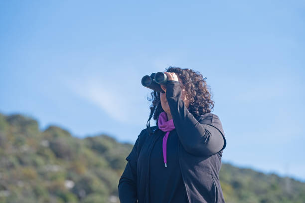 istock A woman birdwatching with binoculars. 1994464626