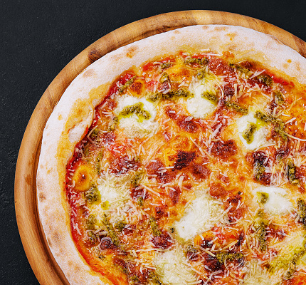Baked vegetarian crusty pizza with mozzarella and pesto sauce