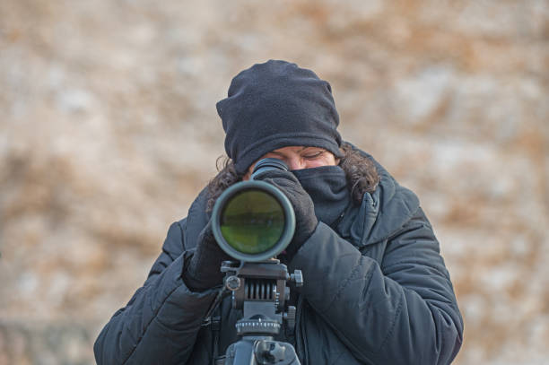 istock Woman birdwatching with a telescope in cold weather. 1994466768